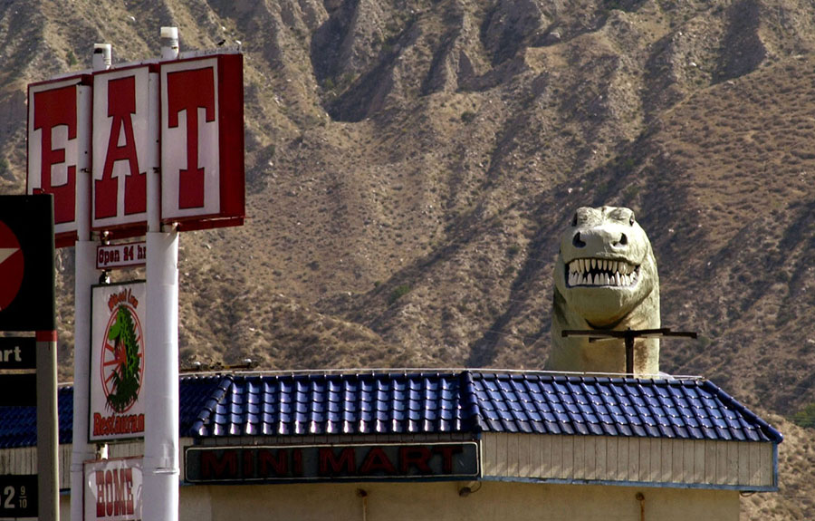 A 60-foot-tall Tyrannosaurus appears behind a restaurant in Cabazon, California, on May 19, 2000. A. The dinosaur is one of two constructed by the late Claude K. Bell as roadside attractions west of Palm Springs. #  David McNew / Newsmakers / Getty