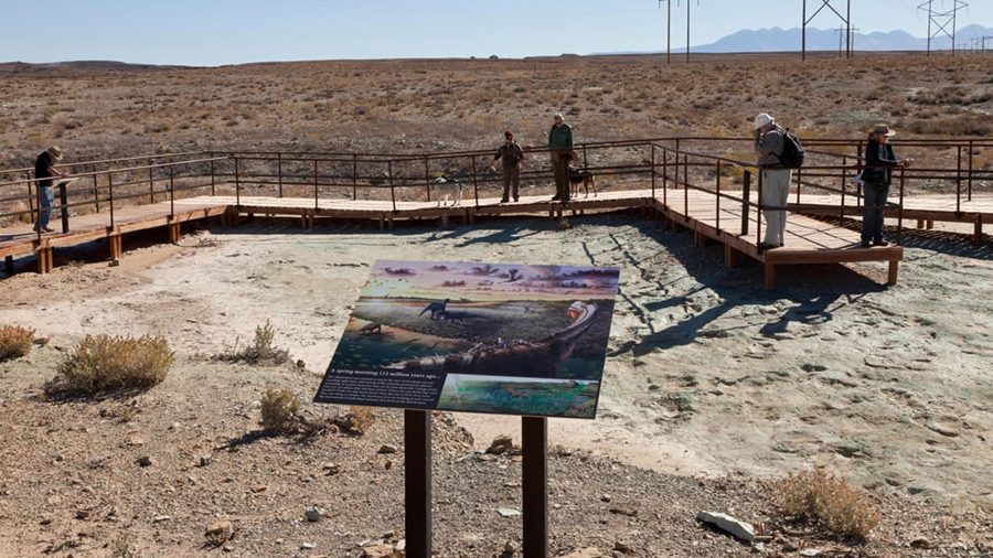 Visitors to the Mill Canyon dinosaur track site can walk along an elevated boardwalk above Early Cretaceous-era tracks and contemplate illustrations such as this one by artist Brian Engh. Alamy