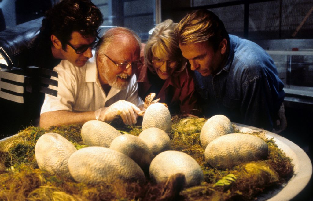 Jeff Goldblum, Richard Attenborough, Laura Dern and Sam Neill watch dinosaur eggs hatch in a scene from the film ‘Jurassic Park’, 1993. | Universal/Getty Images