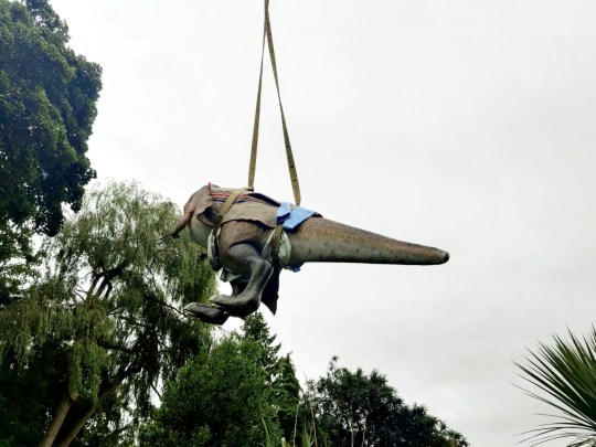 The dinosaur being winched into the garden (Picture: Adrian Shaw / SWNS) 
