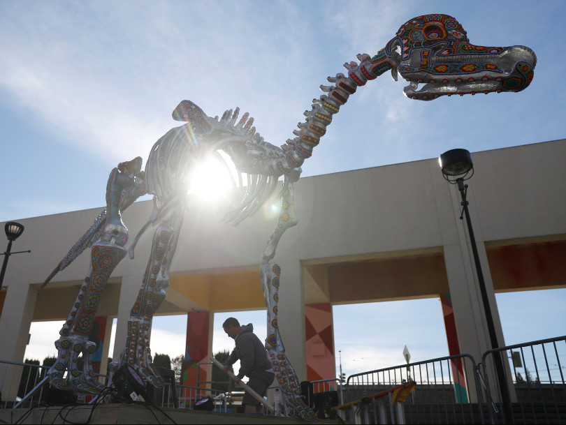 SAN JOSE, CALIFORNIA - FEBRUARY 4: Joseph Trillo, faculty maintenance operations supervisor at Children's Discovery Museum of San Jose, works on the base of "Ichiro," a Velafrons dinosaur by artist Marianela Fuentes, outside of the museum in San Jose, Calif., on Tuesday, Feb. 4, 2020. (Nhat V. Meyer/Bay Area News Group)