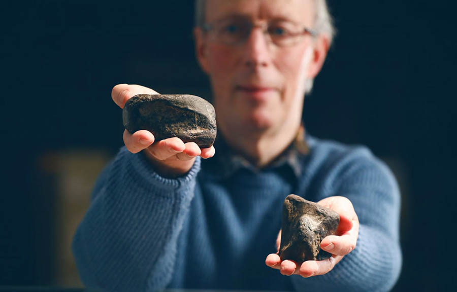 Dr. Simms with the tibia of Sarcosaurus on the left and the femur of Scelidosaurus on the right. Image credit: National Museums Northern Ireland.